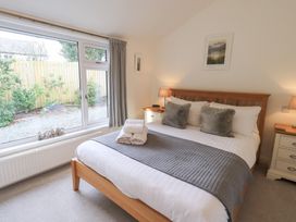 A bedroom with a bed and windows at Mardale in Ambleside