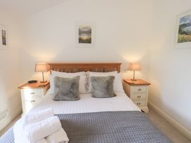 A bedroom with a bed and nightstands at Mardale in Ambleside