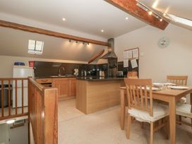 A kitchen with an island, dining table and chairs at Cygnet Cottage Thornthwaite