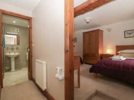 A bedroom with a bed and wardrobe at Cygnet Cottage Thornthwaite