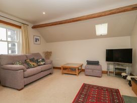 A living room with a sofa and coffee table at Cygnet Cottage in Thornthwaite