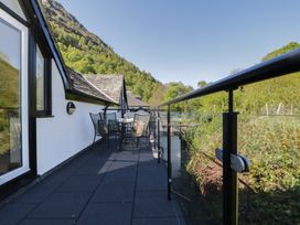 A balcony with a table and chairs overlooking mountains at Cygnet Cottage in Thornthwaite