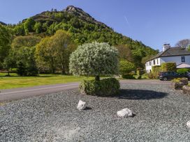 A view of a house with a tree and gravel in front at Cygnet Cottage in Thornthwaite