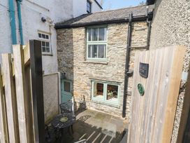 An outdoor area with stone walls and a table and chairs at Chapel Hill Cottage in Ambleside