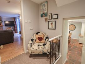 A hallway with a chair and wall art at Chapel Hill Cottage in Ambleside