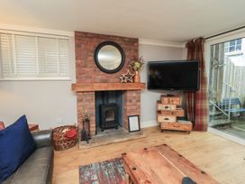 A living room with a fireplace and television at Chapel Hill Cottage in Ambleside