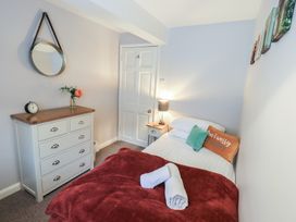 A bedroom with a bed and a dressing table at Chapel Hill Cottage in Ambleside