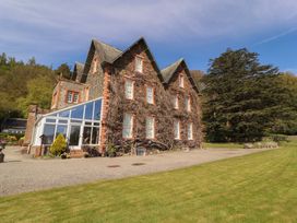 A house exterior with a conservatory and garden at South View in Keswick