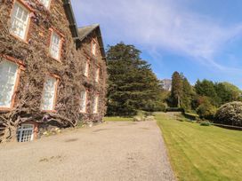 A garden area with a house and trees at South View in Keswick