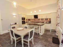 A kitchen with a dining table and kitchen cabinets at South View in Keswick