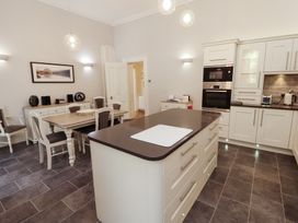 A kitchen with cabinets and dining table at South View in Keswick