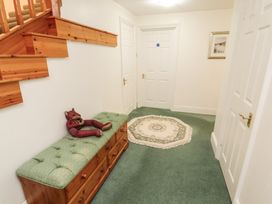 A hallway with a staircase, bench, and rug at South View in Keswick