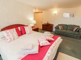 A bedroom with a bed and sofa at South View in Keswick