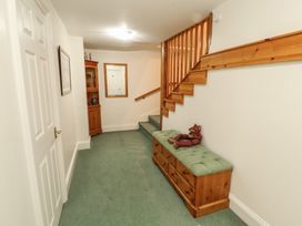 A hallway with a staircase and wooden bench at South View in Keswick