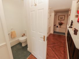 A bathroom with a toilet and sink adjacent to a hallway at South View in Keswick