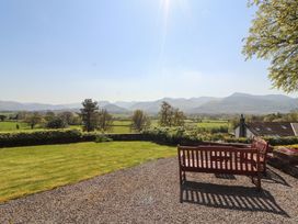 A garden view with a bench and mountains in the background at South View in Keswick