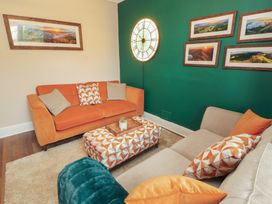 A living room with sofa and ottoman at Gildabrook Cottage in Bowness