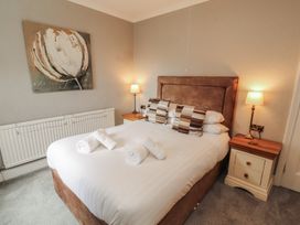 A bedroom with a bed and bedside table at Gildabrook Cottage Bowness