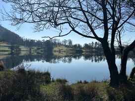 A lake with trees around it and reflections on the water at Puddleduck in Skelwith Bridge near Chapel Stile