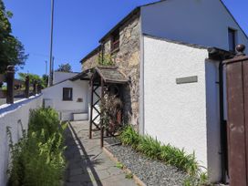Exterior view of a stone and white plaster cottage with a small garden and pathway at The Cottage in Keswick
