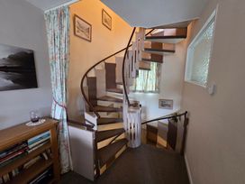 A staircase with a bookshelf and decorative pictures at Mellbreak in Chapel Stile