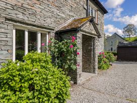 An entrance with plants and a stone wall at Elterwater Lodge in Elterwater