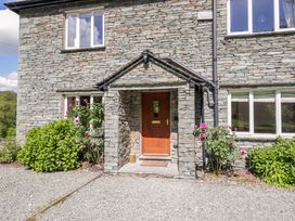 A stone exterior with a front door and garden plants at Elterwater Lodge Elterwater