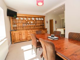 A dining room with a wooden dining table and chairs at Elterwater Lodge in Elterwater
