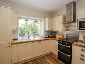 A kitchen with cabinets, a sink, and an oven at Elterwater Lodge in Elterwater