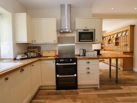 A kitchen with cabinets, oven, kettle, and toaster at Elterwater Lodge in Elterwater