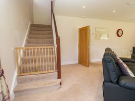 A living room with a staircase and door at Elterwater Lodge Elterwater