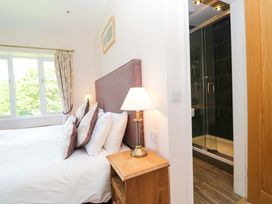 A bedroom with a bed and shower enclosure at Elterwater Lodge Elterwater