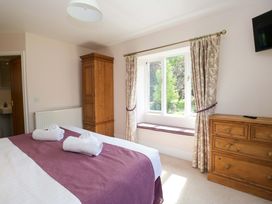A bedroom with a bed and wardrobe at Elterwater Lodge in Elterwater
