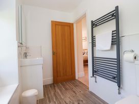 A bathroom with sink, mirror, toilet, and towel rail at Elterwater Lodge, Elterwater