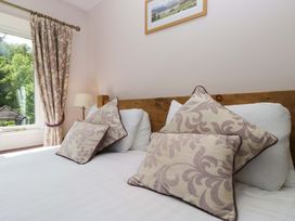 A bedroom with a bed and cushions at Elterwater Lodge in Elterwater