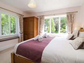 A bedroom with a bed and a wardrobe at Elterwater Lodge Elterwater