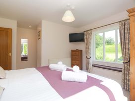 A bedroom with a bed and a television at Elterwater Lodge in Elterwater
