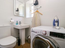 A bathroom featuring a sink, toilet, and washing machine at Elterwater Lodge in Elterwater