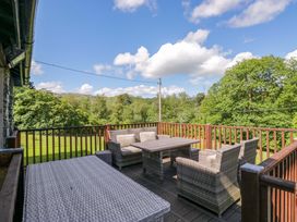 An outdoor deck with seating and a table at Elterwater Lodge in Elterwater