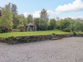 An outdoor area with a gazebo and stone wall at Elterwater Lodge in Elterwater