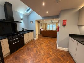 A kitchen with cabinets and an oven at Dancing Beck Cottage in Millbeck