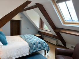 A bedroom with a bed and window at Dancing Beck Cottage in Millbeck