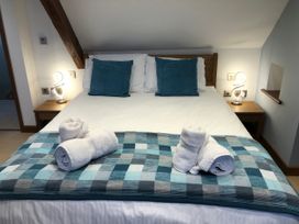A bedroom with a bed and towels at Dancing Beck Cottage in Millbeck