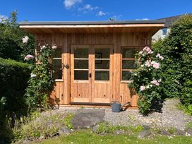 A wooden shed with plants outside in the garden at Grisedale View Keswick
