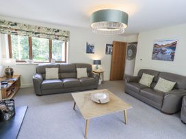 A living room with a sofa, coffee table, and lamp at No 7 in Ambleside