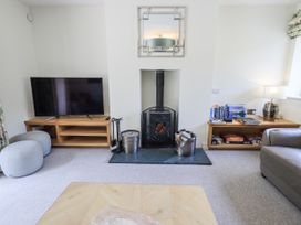 A living room with a television and wood stove at No 7 Ambleside