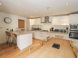 A kitchen with a dining table and stools at No 7 in Ambleside