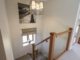 A staircase with a hanging light and a window in the hallway at No 7 Ambleside