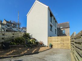 A side view of a building with plants and a wooden gate at Sea View in Penrhyn Bay