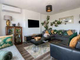 A living room with a sofa and television at Sea View in Llandudno